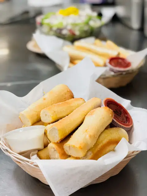 A basket of hot garlic butter breadstix with dipping sauce